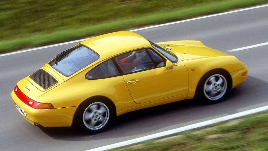 911 Carrera 1994 (993) - Os para-choques foram camuflados como parte da carroceria, tornando o desenho mais leve e moderno | <a href="%20https://gutenberg.quatrorodas.abril.com.br/reportagens/classicos/porsche-911-50-anos-748361.shtml" rel="migration">Leia mais</a>