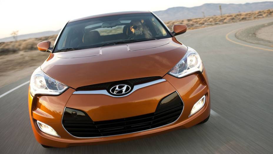 Linhas dinâmicas se unem ao aspecto musculoso do carro | <a href="https://gutenberg.quatrorodas.abril.com.br/carros/lancamentos/hyundai-veloster-641581.shtml" rel="migration">Leia mais</a>