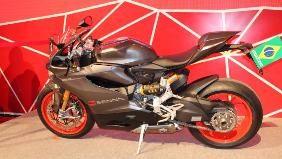 Tendo como base a esportiva Panigale, a moto conta com a cor especial "Cinza Senna" e diferentes grafismos | <a href="https://gutenberg.quatrorodas.abril.com.br/moto/noticias/ducati-revela-1199-panigale-s-senna-salao-duas-rodas-756467.shtml" rel="migration">Leia mais</a>