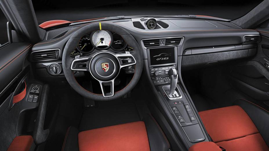 Por dentro, o volante é revestido em couro e também há inserções em fibra de carbono | <a href="https://gutenberg.quatrorodas.abril.com.br/noticias/saloes/genebra-2015/peso-leve-porsche-911-gt3-rs-revelado-842881.shtml" rel="migration">Leia mais</a>