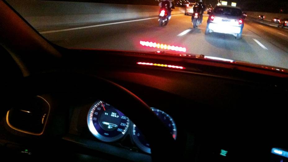 O para-brisa reflete a luz vermelha do City Safety | <a href="https://gutenberg.quatrorodas.abril.com.br/carros/testes/volvo-v60-716488.shtml" rel="migration">Leia mais</a>