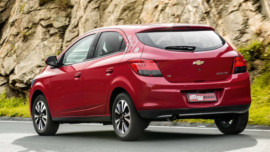 Traseira nem tão original, mas de traços elegantes. Tem sensor de estacionamento e porta-malas com travamento elétrico | <a href="https://gutenberg.quatrorodas.abril.com.br/carros/comparativos/chevrolet-onix-x-chevrolet-agile-729371.shtml" rel="migration"></a>