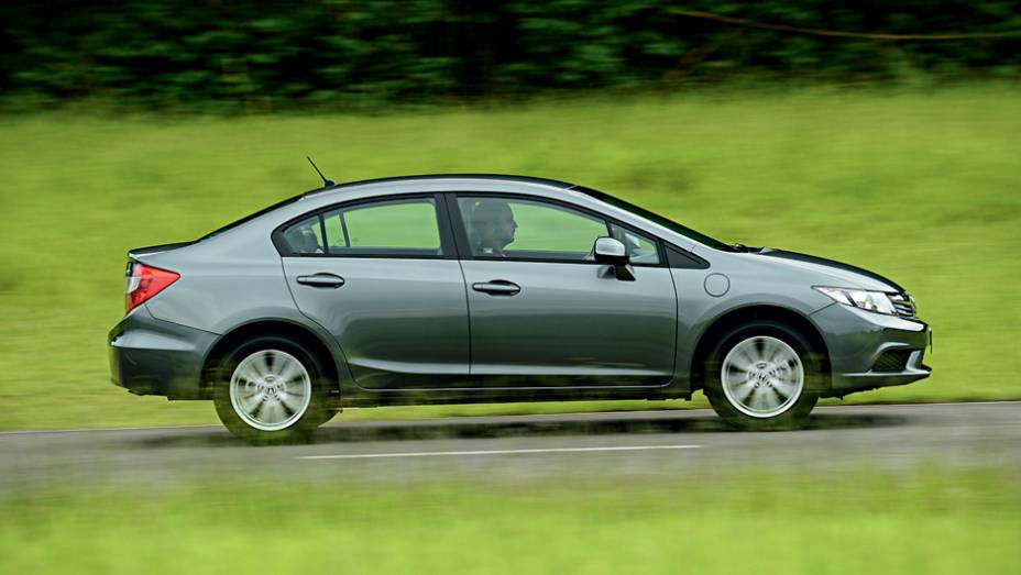 Versão 1.8 tem o sistema de partida a frio tradicional, daí a permanência do segundo bocal no para-lama dianteiro | <a href="https://gutenberg.quatrorodas.abril.com.br/carros/testes/honda-civic-2014-735270.shtml" rel="migration">Leia mais</a>