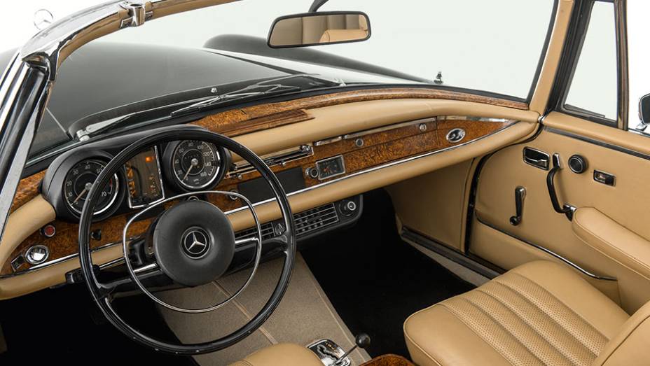 Esmero nos detalhes, painel revestido de couro e uso abundante de madeira | <a href="https://gutenberg.quatrorodas.abril.com.br/carros/classicos-grandescarros/mercedes-benz-w111-740911.shtml" rel="migration">Leia mais</a>