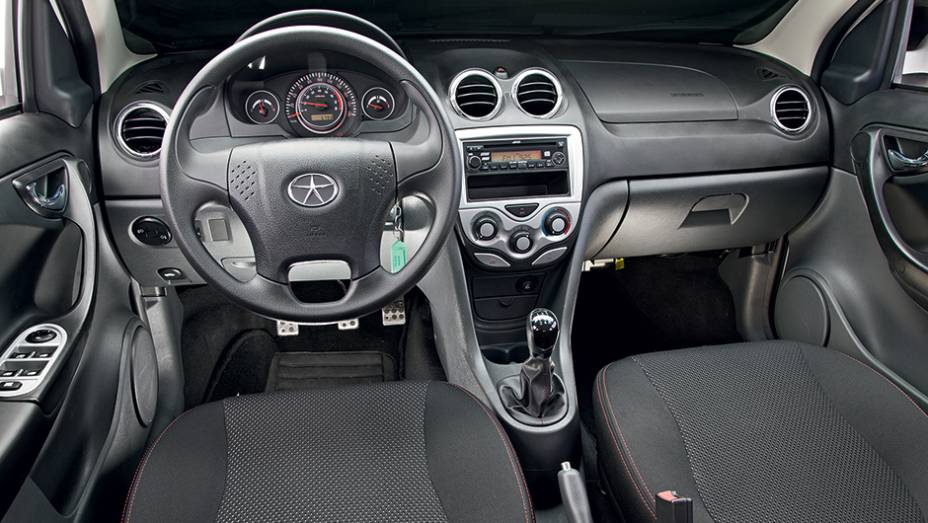 Volante de quatro raios e sa&iacute;das de ventila&ccedil;&atilde;o t&ecirc;m detalhes cromados | <a href="https://gutenberg.quatrorodas.abril.com.br/carros/comparativos/jac-j3-1-5-s-x-chery-celer-1-5-744920.shtml" rel="migration">Leia mais</a>