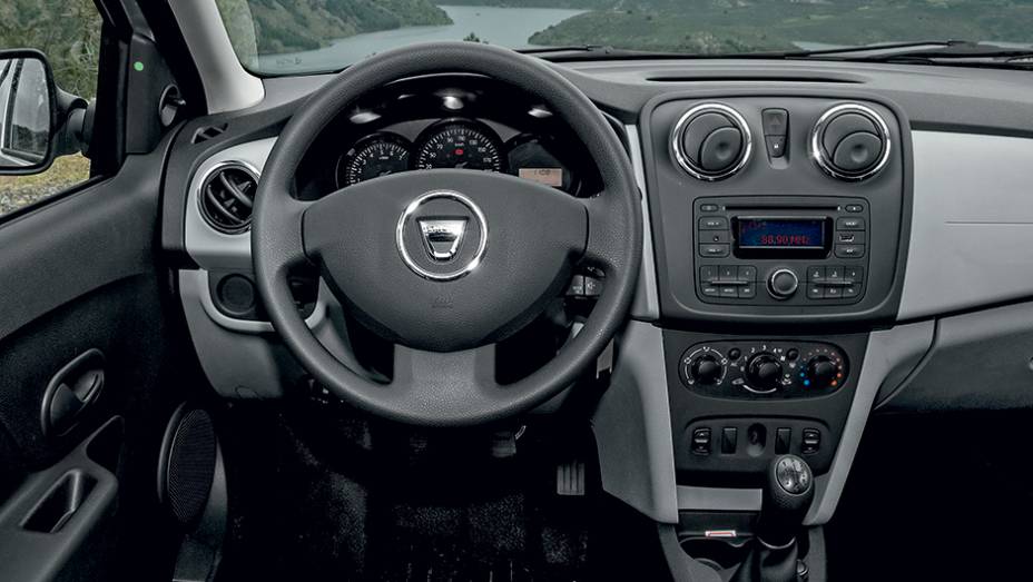 Interior farto em acabamento de pl&aacute;sticos duros, inclusive no volante | <a href="https://gutenberg.quatrorodas.abril.com.br/carros/impressoes/dacia-logan-749339.shtml" rel="migration">Leia mais</a>