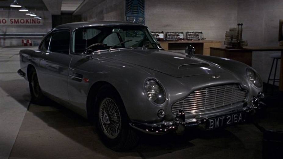 1964: O mais famoso veículo utilizado pelo espião estreia em "007 contra Goldfinger": o Aston Martin DB5. | <a href="%20https://gutenberg.quatrorodas.abril.com.br/blogs/planeta-carro/2012/11/07/licenca-para-acelerar/" rel="migration">Leia mais</a>