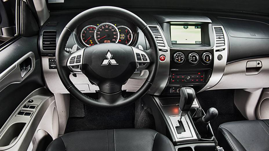 Bancos de couro e console central com acabamento que imita tit&acirc;nio | <a href="https://gutenberg.quatrorodas.abril.com.br/carros/testes/mitsubishi-pajero-dakar-hpe-765655.shtml" rel="migration">Leia mais</a>
