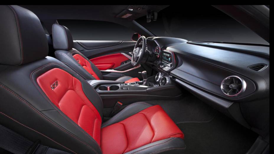 Interior apresenta bancos esportivos em couro com costura contrastante, que também se estende para os painéis de portas e console | <a href="https://gutenberg.quatrorodas.abril.com.br/noticias/fabricantes/chevrolet-mostra-camaro-2016-865740.shtml" rel="migration">Leia mais</a>