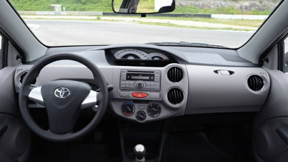 O interior tem materiais simples, como todo popular, e painel em posi&ccedil;&atilde;o central | <a href="https://gutenberg.quatrorodas.abril.com.br/salao-do-automovel/2012/carros/toyota-etios-703992.shtml" rel="migration">Leia mais</a>