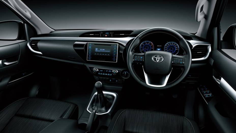 Interior tem conforto de um carro com destaque para a grande tela da central multimídia no painel | <a href="https://gutenberg.quatrorodas.abril.com.br/noticias/fabricantes/toyota-revela-nova-hilux-2016-867763.shtml" rel="migration">Leia mais</a>