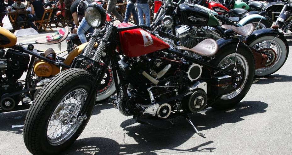 Bobber com frente springer baixa, pneu traseiro adaptado e sem freio frontal, rabo duro, selin fino de couro com molas e motor H-D | <a href="https://gutenberg.quatrorodas.abril.com.br/moto/noticias/two-wheels-brazil-reune-fabricantes-nacionais-americanos-motos-vinta" rel="migration"></a>