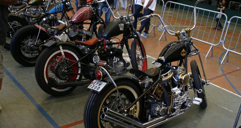 Choppers com frente springer e guid&atilde;o elevado, quadro rabo duro, pneus faixa branca e motores H-D de diferentes gera&ccedil;&otilde;es | <a href="https://gutenberg.quatrorodas.abril.com.br/moto/noticias/two-wheels-brazil-reune-fabricantes-nacionais-americanos-motos-vintage-644346." rel="migration"></a>
