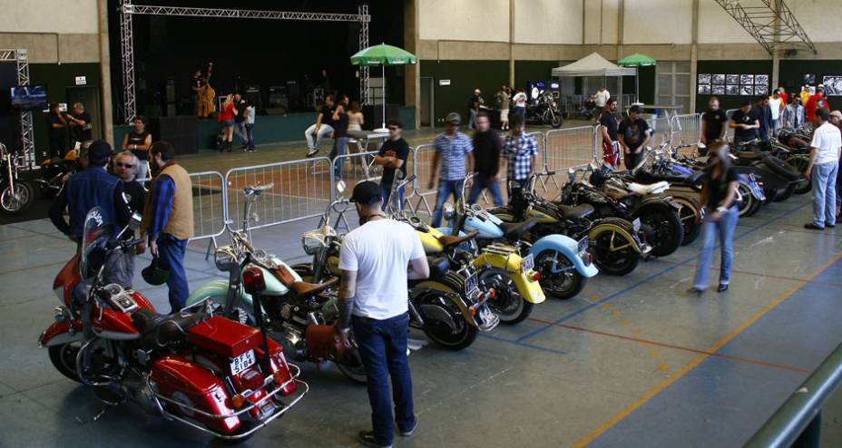 Motos Harley-Davidson customizadas alinhadas no gin&aacute;sio que recebeu o evento Two Wheels na zona sul de S&atilde;o Paulo | <a href="https://gutenberg.quatrorodas.abril.com.br/moto/noticias/two-wheels-brazil-reune-fabricantes-nacionais-americanos-motos-vintage-644346.shtml" rel="migration">Le</a>