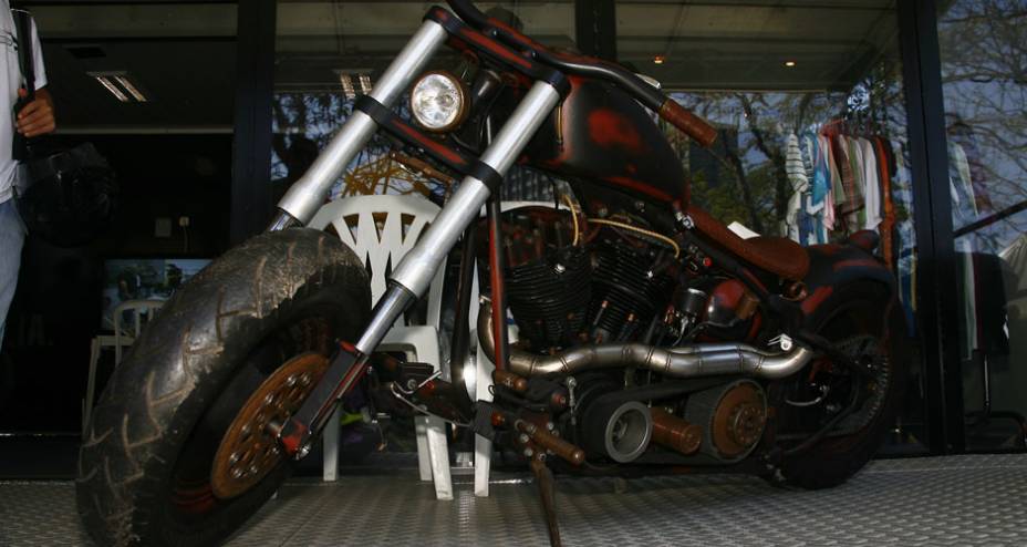 Moto ao estilo Rat Bike surgida a partir dos personagens do filme Mad Max, com motor HD antigo e frente com suspens&atilde;o invertida adaptada | <a href="https://gutenberg.quatrorodas.abril.com.br/moto/noticias/two-wheels-brazil-reune-fabricantes-nacionais-americanos-motos" rel="migration"></a>