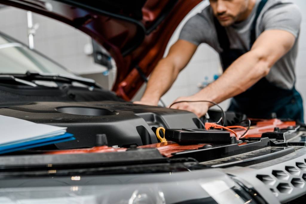 Mecânico analisa o motor de um carro Mecânico analisa o motor de um carro