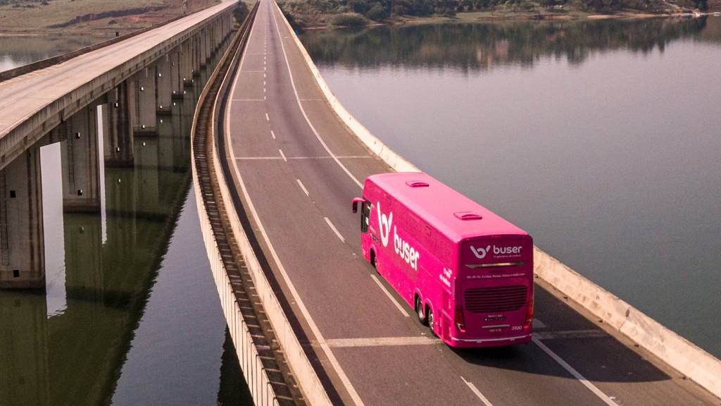 BUSER Ônibus da Buser rosa visto por cima de trás