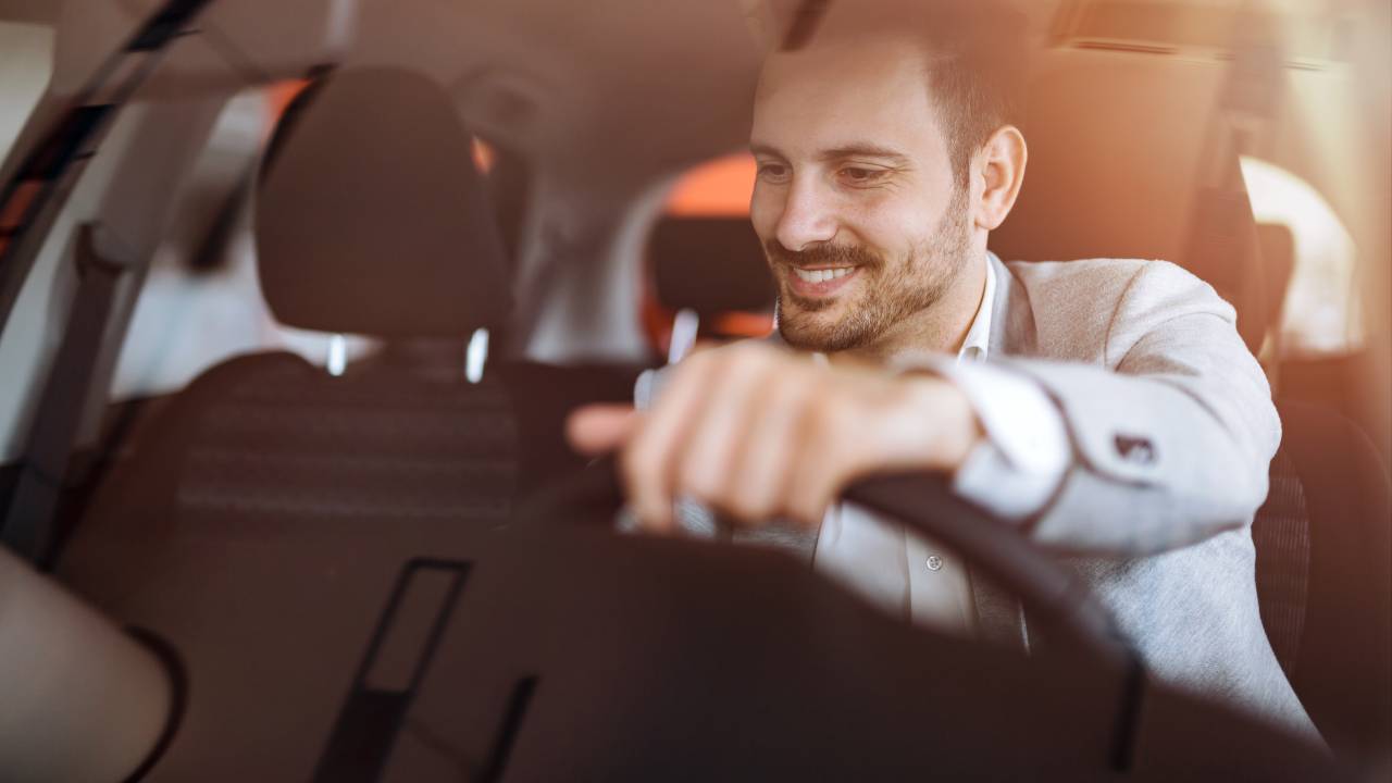 Homem branco dirigindo carro antes de comprá-lo